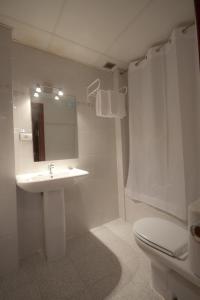 a bathroom with a sink and a toilet and a mirror at Hotel Fornos in Calatayud