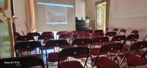 una sala de conferencias con sillas rojas y una pantalla de proyección en ART HOUSE VENUSIO Naples, en Nápoles