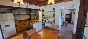 a kitchen with a wooden table and a refrigerator at Casa Nico in San Carlos de Bariloche