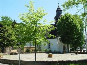 a church with a tower on top of a building at Pension Deimel in Hallenberg