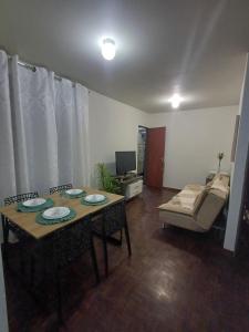 a living room with a table and a couch at Cê Achegue Aqui Uai in Contagem