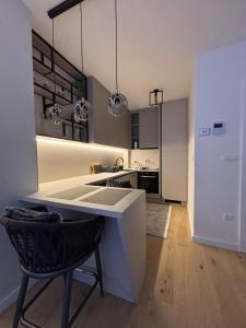 a kitchen with a white counter and a black chair at Alpha in Bjelašnica