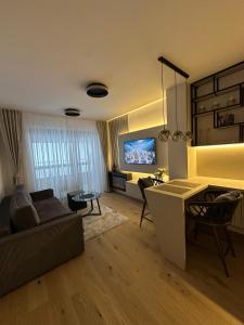 a living room with a couch and a tv at Alpha in Bjelašnica