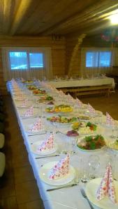 uma mesa longa com pratos de comida em Vizbulites em Pulkarne