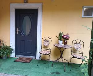 two chairs and a table in front of a door at Old Town Cozy Nest in Sibiu