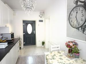 a kitchen with a black door and a clock on the wall at Old Town Cozy Nest in Sibiu