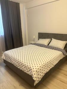 クラヨーヴァにあるAdela Luxury Houseのベッドルーム1室(ベッド1台、白黒の掛け布団付) +4枚の写真
