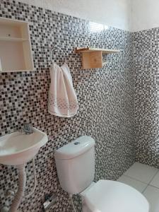 a bathroom with a white toilet and a sink at Chalé Cantinho do Céu- Santo Amaro do MA in Santo Amaro +8 photos