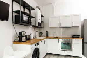 a kitchen with white cabinets and a washer and dryer at FamilienZeit Apartments in Bremerhaven