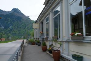 a building with potted plants on the side of a street at Maison d'hôtes "Hôtel de la Gare" in Montbovon