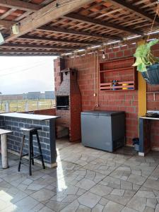 a outdoor kitchen with a pizza oven and a brick wall at Chalé 01 cantinho do ceu in Santo Amaro