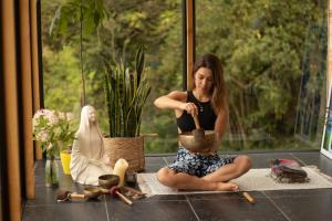a woman sitting on the floor working on a pottery at Cúspide Lodge - Choachí in Choachí