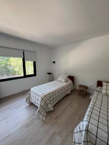 Un dormitorio con dos camas y una ventana. en Senderos del Mar II, en Monte Hermoso