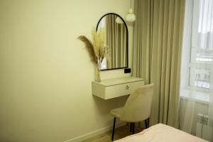 a bedroom with a mirror and a chair and a bed at Apartments on Khan Shatyr in Astana