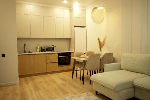 a kitchen and living room with a couch and a table at Apartments on Khan Shatyr in Astana