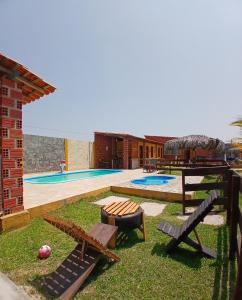 a backyard with a pool with two benches at Chalé cantinho do ceu in Santo Amaro