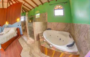 a large bathroom with a tub and a bed at Arenal Tropical Home Villa in Fortuna
