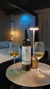 een fles wijn en twee wijnglazen op een tafel bij Love room Saphir in Niederbetschdorf