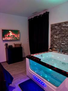 a hot tub in a room with a tv at ღ L'escapade romantique ღ de la Vill'ona - LOVEROOM -Ardèche in Grospierres