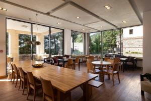 a restaurant with a large wooden table and chairs at Natura Hotel Vytina in Vitina