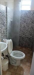 a bathroom with a toilet and a sink at Viver Massaguaçu Suíte 2 in Caraguatatuba