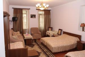 1 Schlafzimmer mit 2 Betten, einem Stuhl und einem Kronleuchter in der Unterkunft Hotel MIRA in Goris