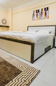 a bedroom with a large bed with a rug at المعالي Apartment مسقط in Ghursheba