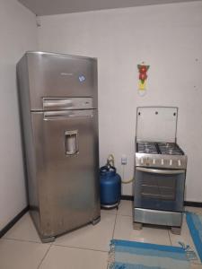 una cucina con frigorifero in acciaio inox e fornello di Casa para temporada Balneário de Carapebus a Serra