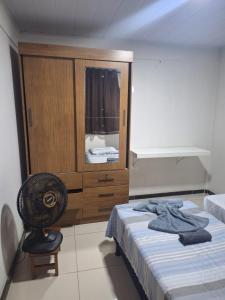 una camera da letto con un letto, un armadio e una sedia di Casa para temporada Balneário de Carapebus a Serra Altre 19 foto