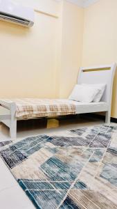 a bed in a room with a rug at المعالي Apartment مسقط in Ghursheba