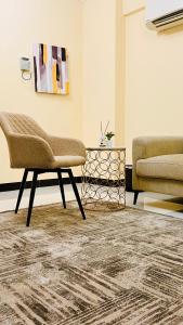 a living room with a chair and a table at المعالي Apartment مسقط in Ghursheba