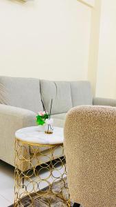 a living room with a couch and a coffee table at المعالي Apartment مسقط in Ghursheba