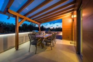 a dining room with a table and chairs on a balcony at Holiday House Libra in Jadrija
