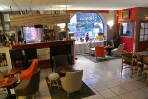 a restaurant with tables and chairs and a bar at Hotel Regina in Saint-Nectaire