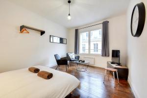 a bedroom with a bed and a table and chairs at Apartment Place Stanislas 3 in Nancy