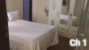 a bedroom with a white bed and a dresser at Darrou Salam house in Rufisque