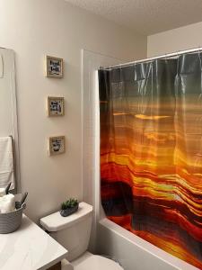 a bathroom with a shower with a colorful shower curtain at Luxurious, Centrally Located Home in Cavanagh in Edmonton