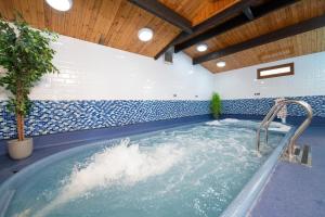 a jacuzzi tub in a room with blue and white tiles at Elf Wood Lodge - Swimming Spa, Sky Sports, Tennis, Hadrian's Wall listing in Port Carlisle