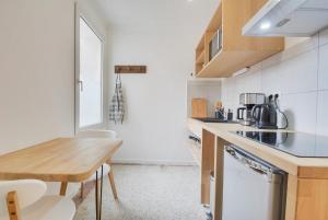 een keuken met een houten tafel en een houten aanrecht bij Appartement Place Stanislas 4eme in Nancy +11 foto's