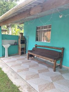 a blue house with a bench on a patio at Caminho da Praia in Parati-Mirim