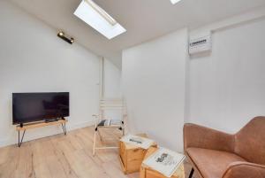 een woonkamer met een flatscreen-tv en een bank bij Appartement Place Stanislas 5eme in Nancy