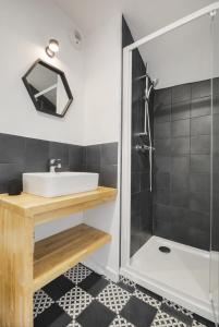 een badkamer met een wastafel en een douche bij Appartement Place Stanislas 5eme in Nancy