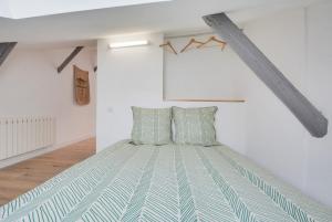 een slaapkamer met een bed in een witte kamer bij Appartement Place Stanislas 5eme in Nancy