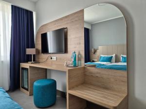 a bedroom with a desk and a bed with a mirror at Hotel Atlas Halle in Halle an der Saale +56 photos