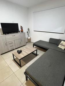 un salon avec deux canapés et une télévision à écran plat dans l'établissement Terra Bella Hidromasajes, à San Antonio de Arredondo