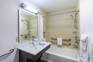 a bathroom with a sink and a tub and a mirror at Candlewood Suites Hattiesburg by IHG in Hattiesburg +18 photos