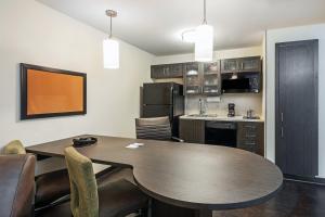 a kitchen and dining room with a table and chairs at Candlewood Suites Hattiesburg by IHG in Hattiesburg