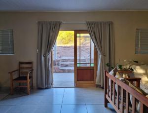 a bedroom with a bed and a sliding glass door at Lambertshoek Farm Stay in Clanwilliam