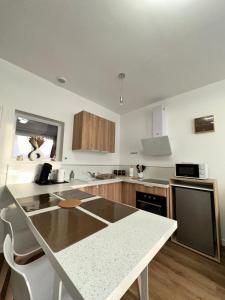a kitchen with a table and a counter top at Casa Armando, beau F2, 2 places de parking clos, proche Disneyland in Quincy-Voisins
