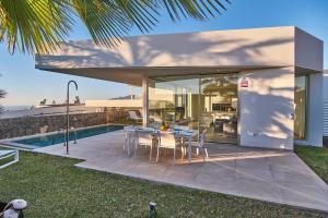 a glass house with a table and chairs on a patio at Abama Lux Tenerife in Tejina de Isora